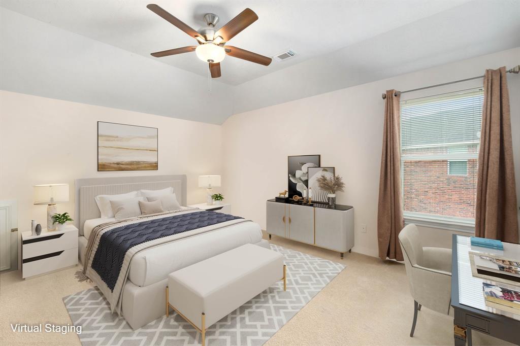 Secondary bedroom features plush carpet, custom paint, dark stained ceiling fan with lighting and a large window with privacy blinds.