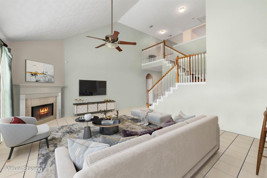 This living room is more like a GREAT room featuring a stunning fireplace with mantel detailing, soaring high ceiling, dark stained ceiling fan, and an amazing wall of windows providing a lovely view of your backyard to keep an eye out on the kids or pets playing.