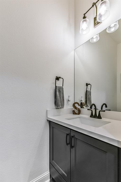 Half bath has custom cabinet with toe-kick drawer for extra storage.