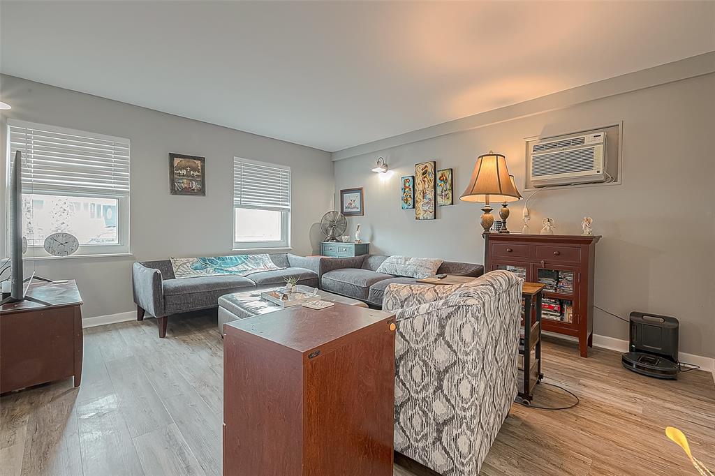 The living area features windows over looking front courtyard.  Windows allow for ample natural light and creating a sense of openness.