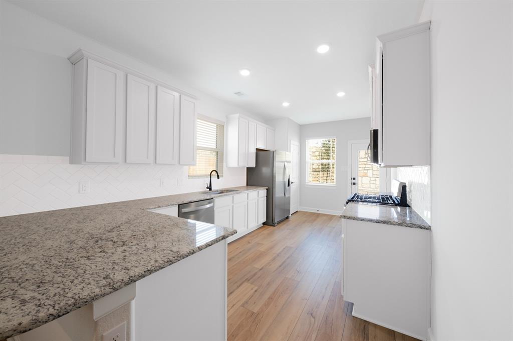 White cabinets in the kitchen impart an air of modern sophistication, enhanced by the striking allure of beautiful granite countertops