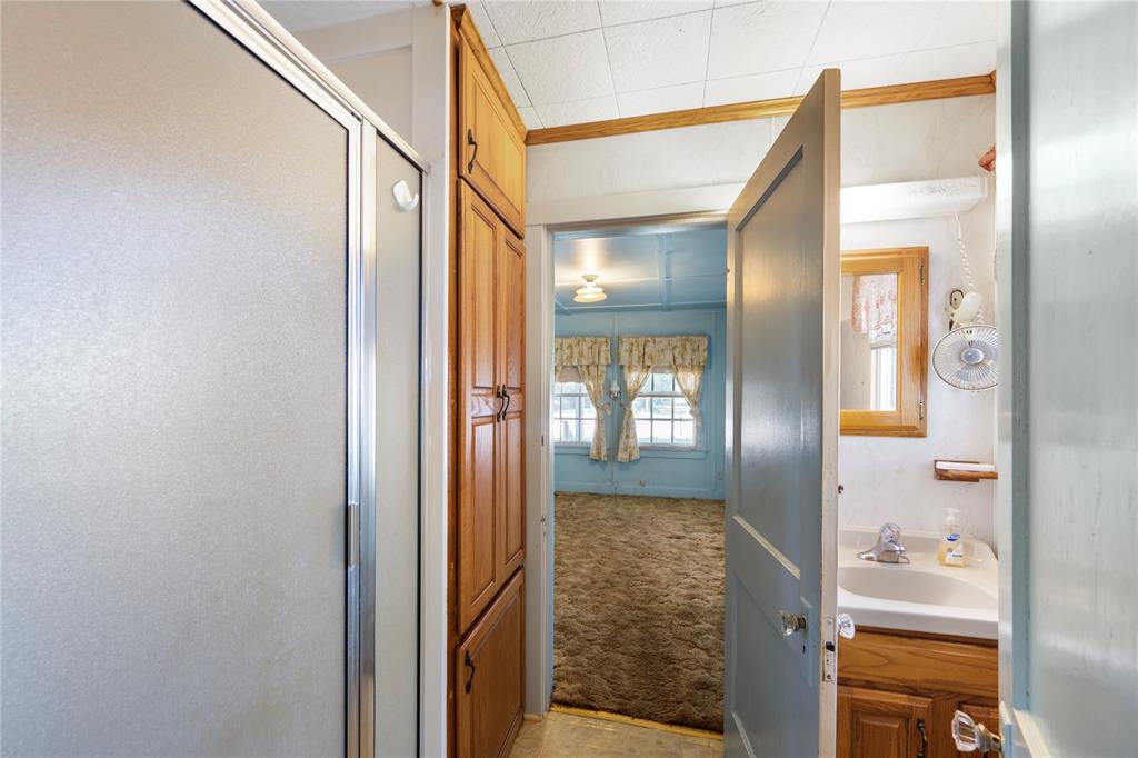 Bath has shower, sink with vanity cabinet and toilet along with some cabinet storage.  Bath is also accessible to front bedroom.