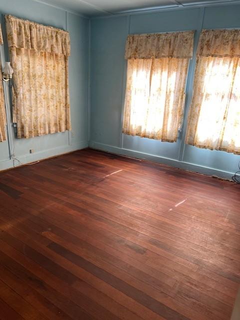 View of front bedroom with hardwood floors after sellers removed carpeting. Wood floors are in good condition and original to home.