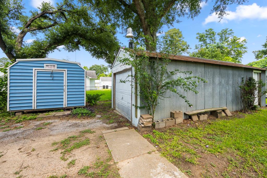 There is a corrugated metal garage on a slab with some shelving, a roll up door and lights.  10x10 portable building to the left provides additional storage.