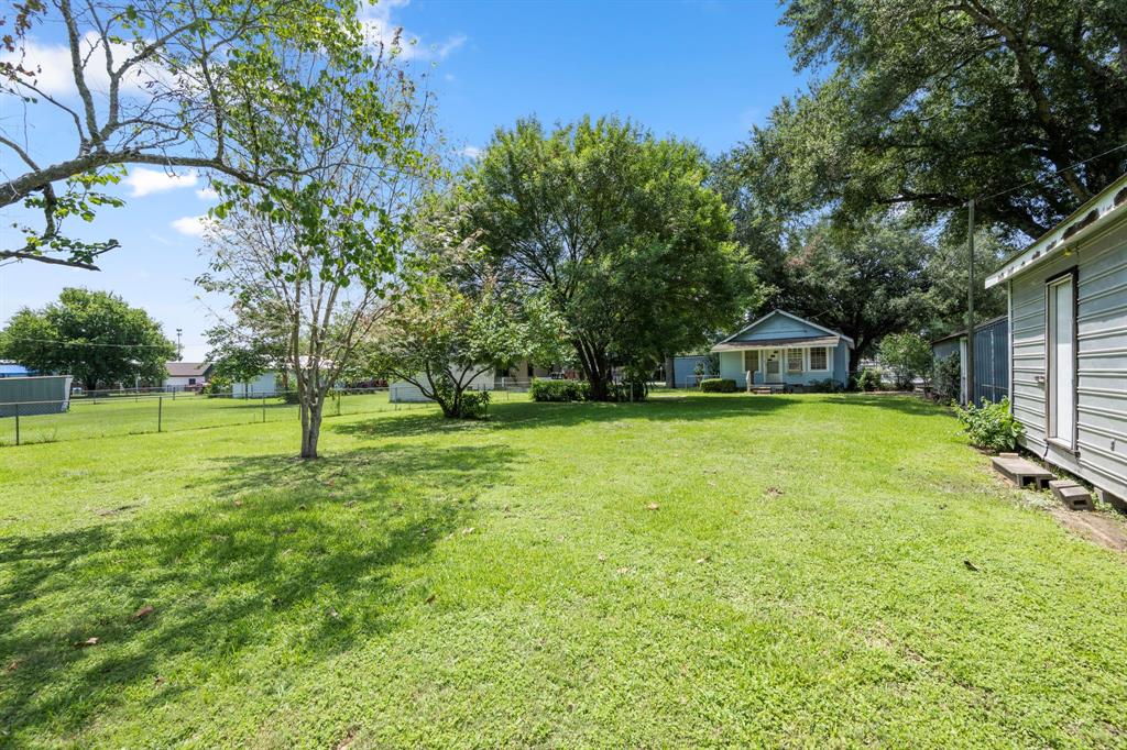 View of lot from back of property showing location of buildings to each other. Most of lot is surrounded by hurricane metal fencing.