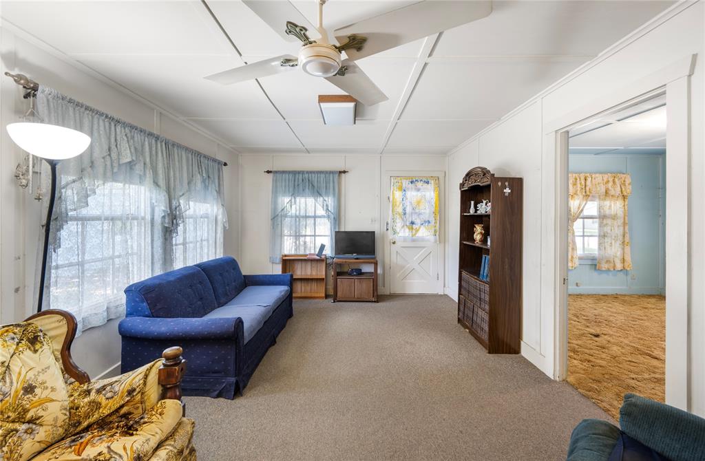 Additional view of living room looking back at front door.  Front bedroom is to the right. Home is cooled by window unit.