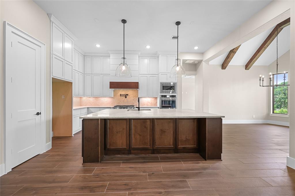 Updated picture as of May 26th: Floors are installed. Custom built-ins that flank the fireplace are finished as well. Fireplace mantle beam will be next. Kitchen cabinets almost completed.