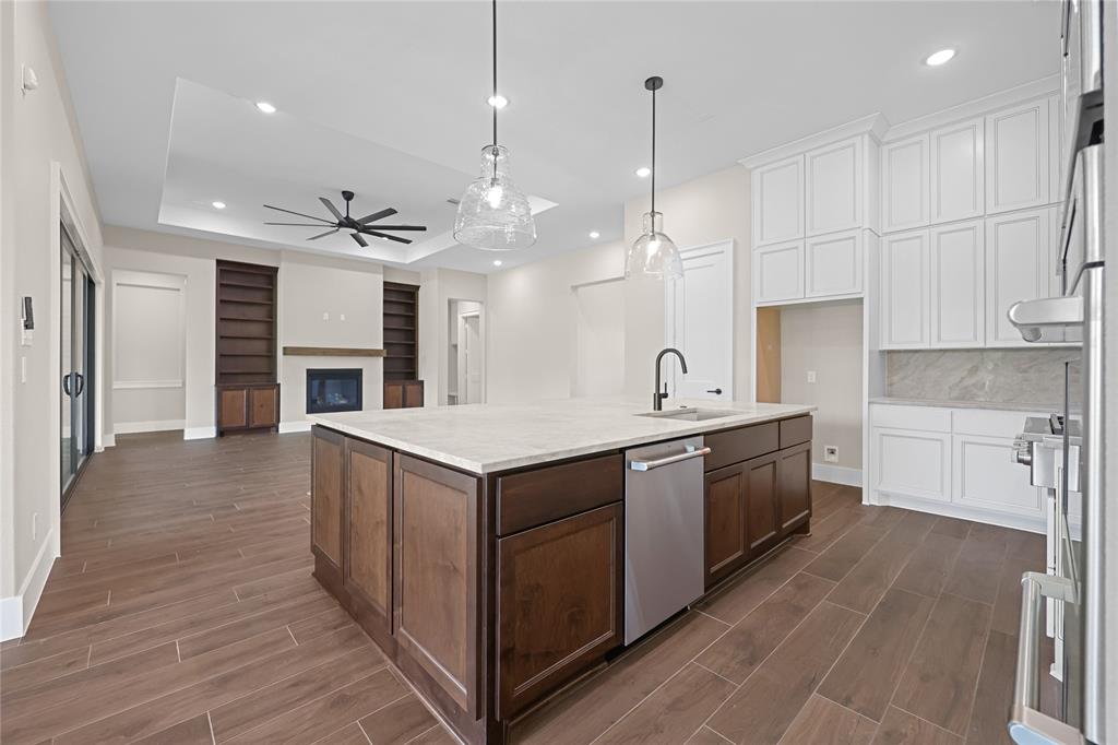 Closer look at this gourmet kitchen with custom vent hood and cabinetry. Closed door to the left is the walk-in pantry.