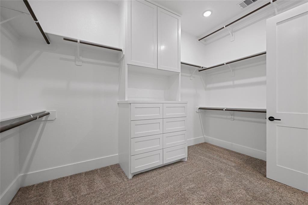 Large primary closet with built-ins for clothes and shoes storage. In fact, all bedroom closets in this home are spacious walk-ins.