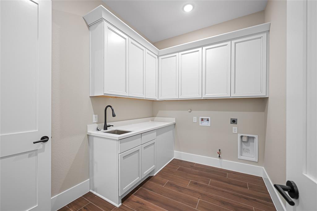 Through the primary closet, you can access this utility room with extra storage and cabinet space. White counters to be installed next. Utility room also leads into a front hallway to a secondary bedroom.