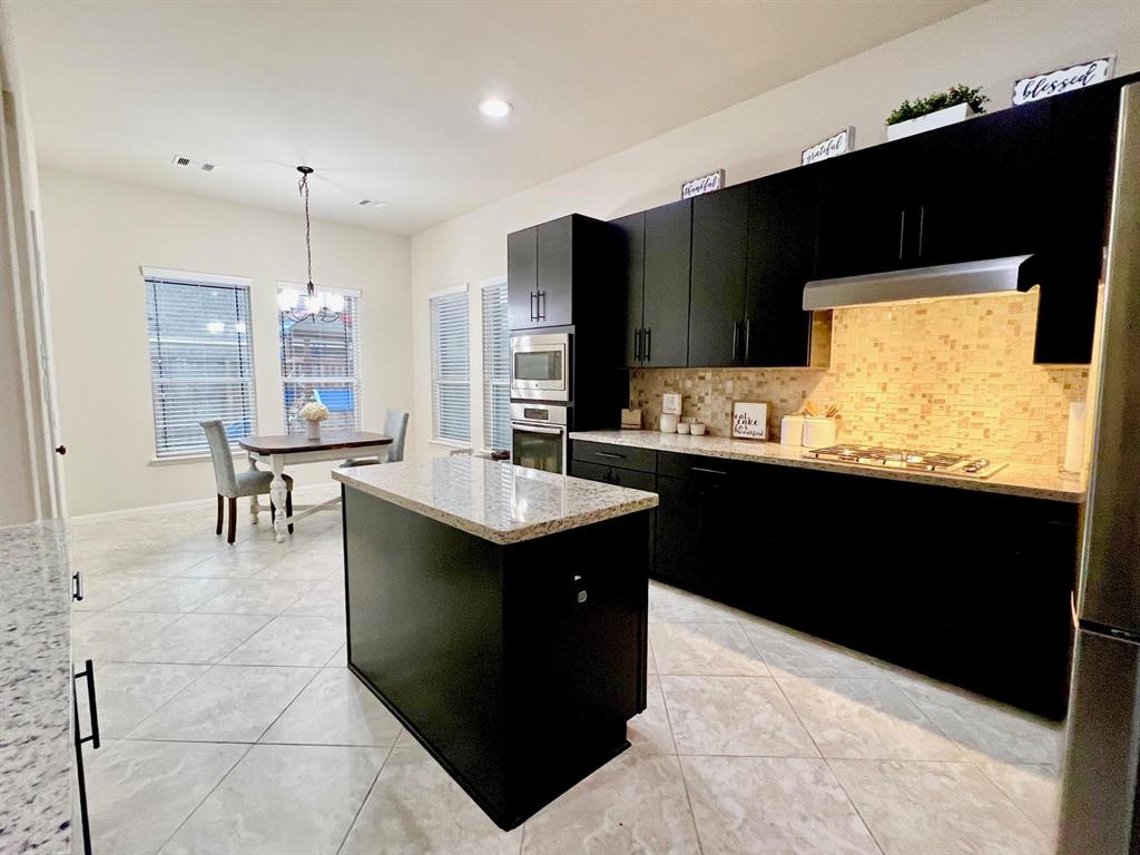 The spacious kitchen area with lots of cabinets and counter space.