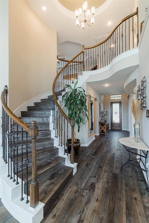 The rotunda features a tray ceiling, chandelier and curved stair case with wrought iron spindles that leads you upstairs.