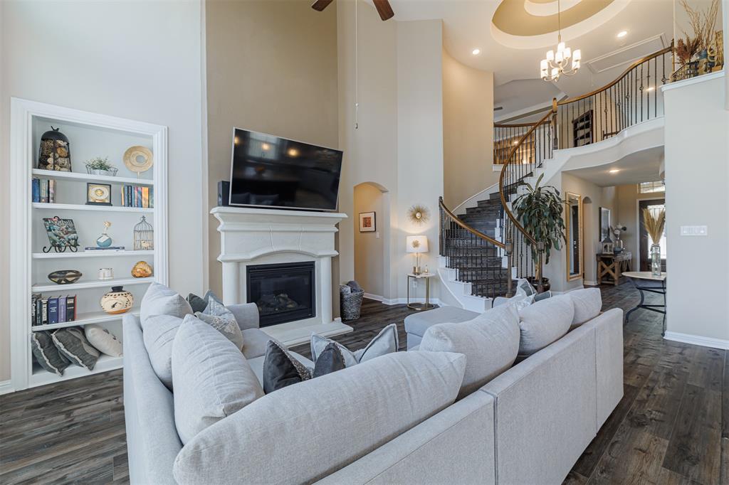 Another view of the family room showing the soaring ceilings and looking toward the curved staircase.