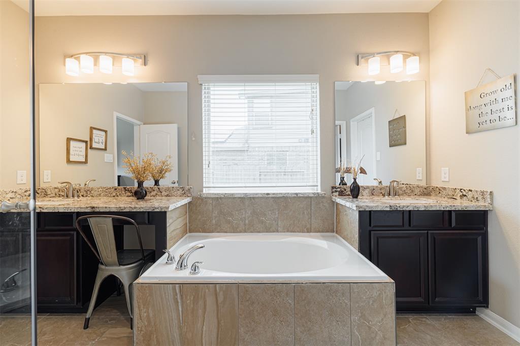 The primary bath also features his and hers sink area and vanity along with a soaking tub.