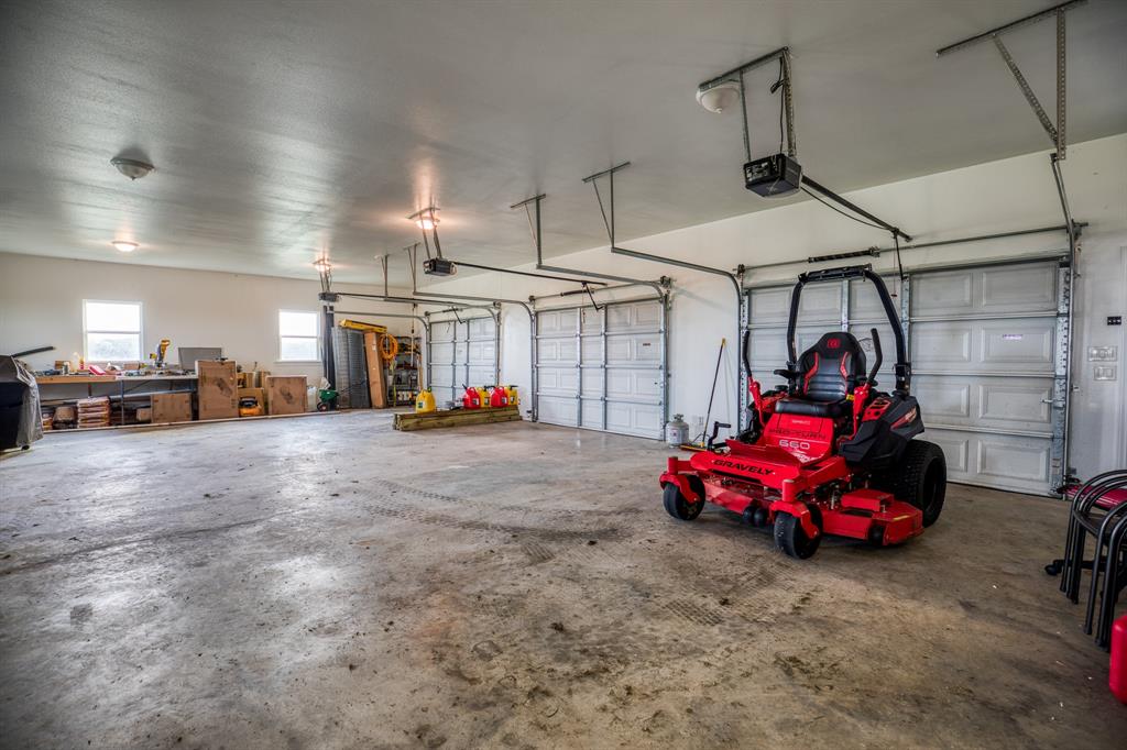 This vast area offers plenty of room for vehicles, tools, and equipment, making it an essential feature for any homeowner. The polished concrete floors and high ceilings enhance the sense of space, while multiple windows ensure the area is well-lit with natural light.