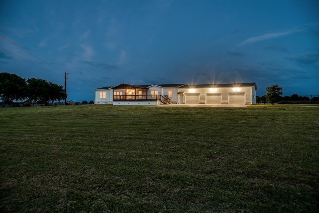 Exterior lights illuminate the expansive façade, highlighting the architectural beauty of this charming property. The front and back decks are elegantly lit, creating a cozy and welcoming atmosphere that invites you to relax and unwind.