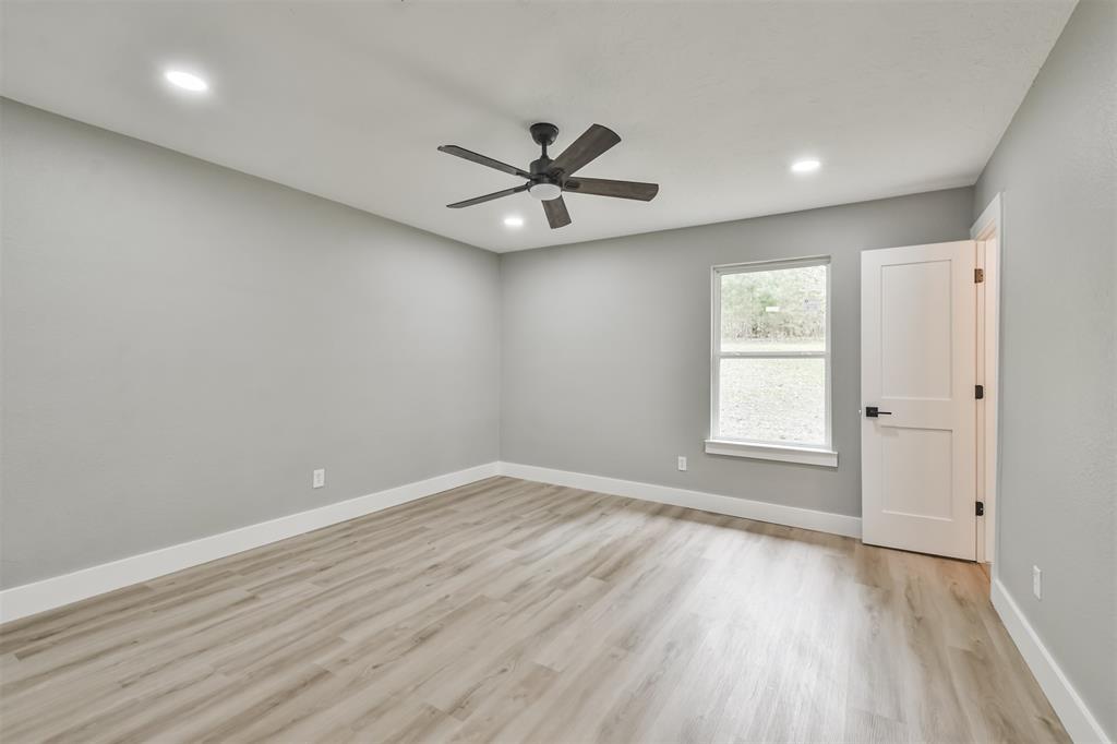 The Primary bedroom features that same beautiful flooring and a ceiling fan!