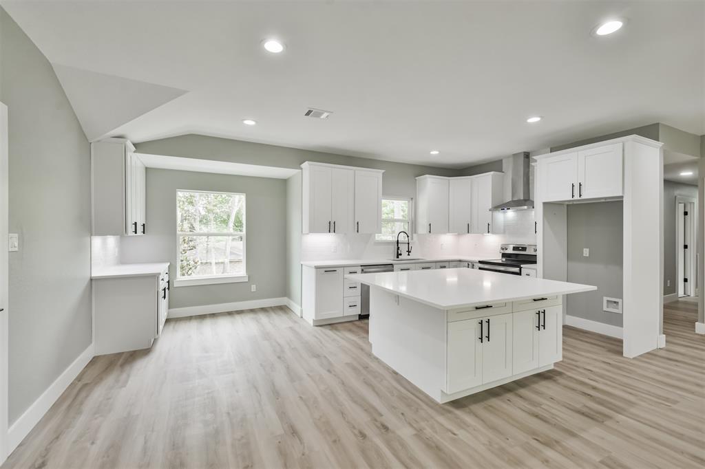 The kitchen features a large island with quartz countertops and stainless steel and black appliances! The undercabinet lighting adds a special touch!