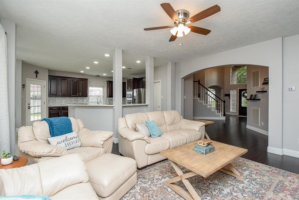 From this huge living area, you can appreciate this comfy view right up to the front door; a glimpse of the staircase, and a full view of the amazing kitchen, up center.