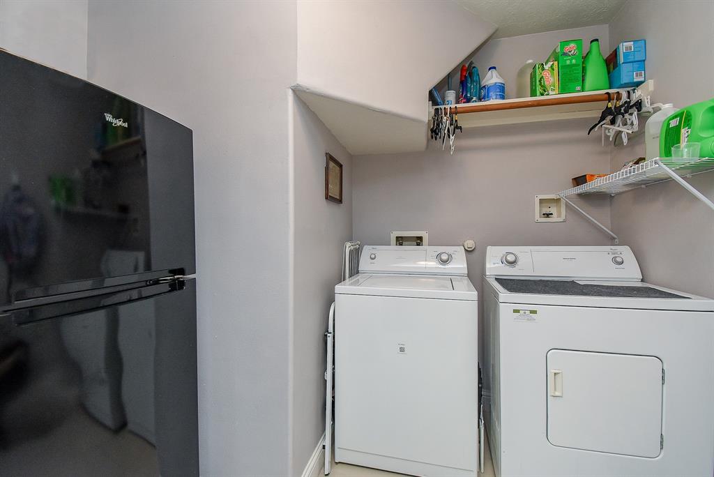 The spacious utility room provides ample space for dual laundry appliances and an extra fridge, too!