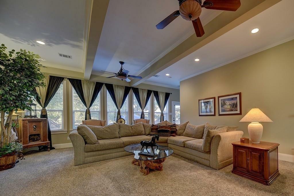 The expansive den has a double sided fireplace and a full wall of windows with a great view of the property.