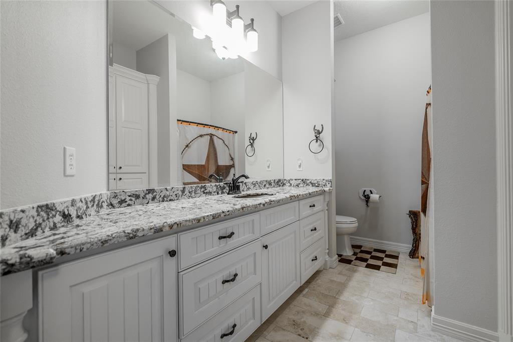 Please notice the long and exotic granite counter tops. The sink is hammered copper and matches the copper in the counter tops perfectly. The floors are natural Travertine tile.