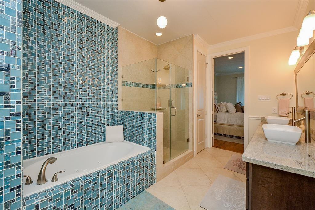 A literal blue heaven has moved into your primary ensuite bath; easy on the eyes and senses and huge! A stunning framed wall mirror sits atop dual, above counter sinks, while this rimless, glass enclosed shower and welcomed bench sit right next to the relaxing soaker!