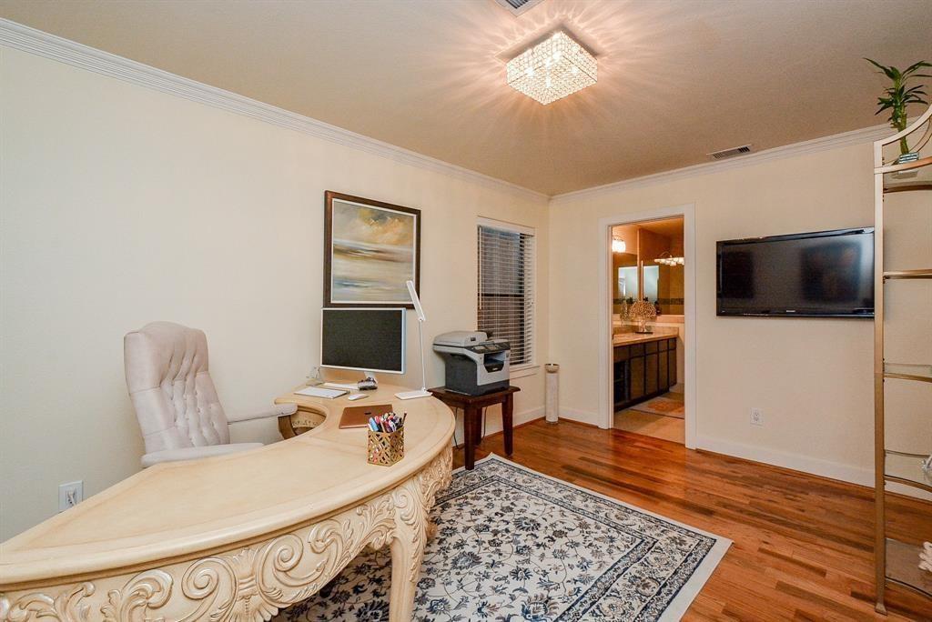 This downstairs bedroom features a full bathroom and beautiful wood floors.