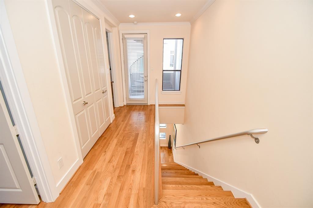 The wood floors are all over including the hallways. This hallway has access to the laundry area behind double doors. Notice the bright skylight bringing in plenty of natural light.