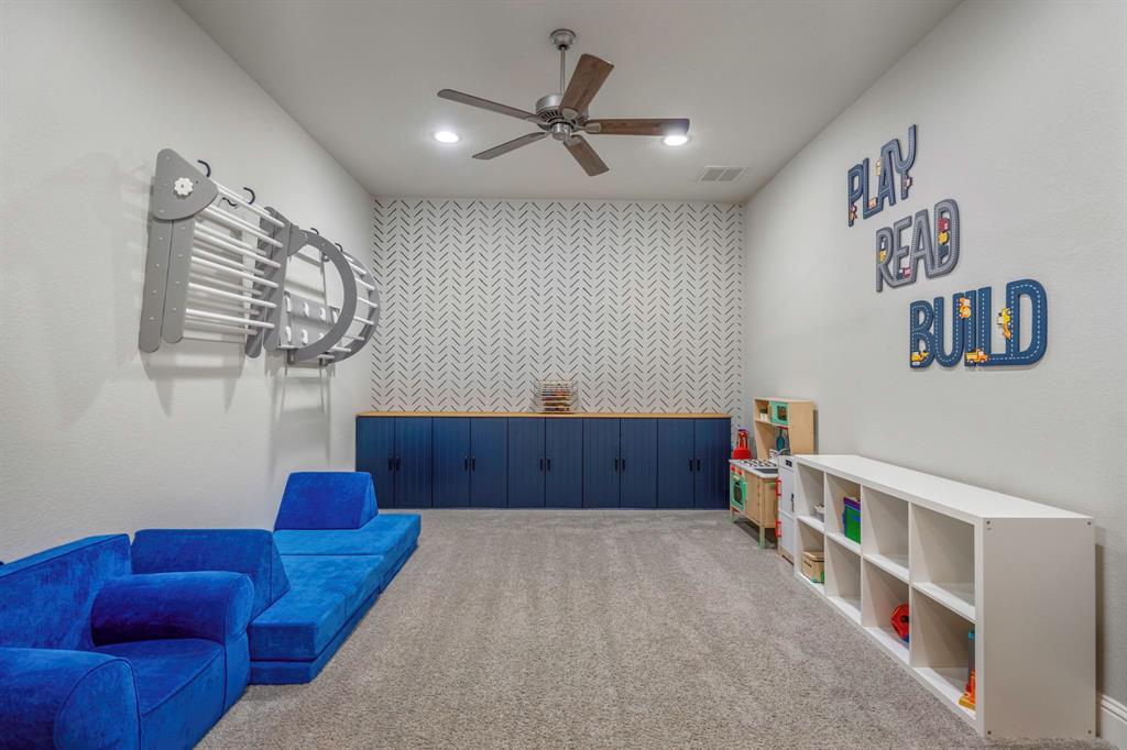 The first of the secondary bedrooms sits at the frot of the home and features bright natural light, ceiling fan with light, and plush carpet.