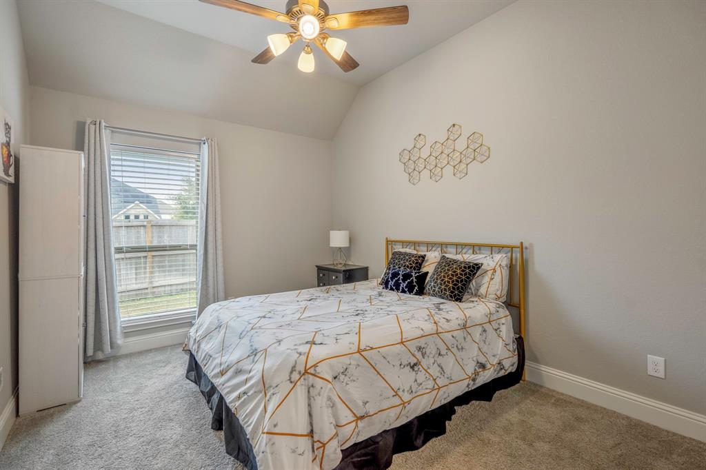 This ensuite bathroom is connected to the last of the secondary bedrooms and features an oversized vanity with gray cabinets, quartz countertops, large mirror, and a combination tub and shower.