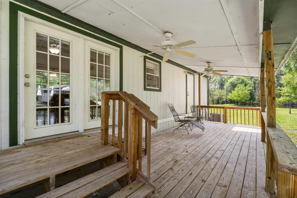 Private oasis! A serene wooden deck with a fan, inviting relaxation amidst greenery. Comfortable chairs beckon for peaceful moments in a tranquil, homey setting.