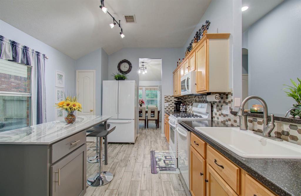 A gourmet kitchen with custom cabinetry, a gas range and stylish backsplash