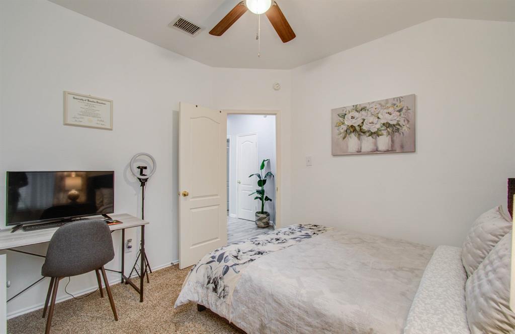 A bright and cheerful bedroom with carpet and spacious study area