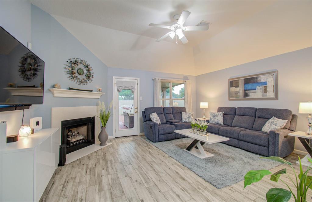 This inviting family room features a cozy gas fireplace, ample natural light and open lay out perfect for gatherings