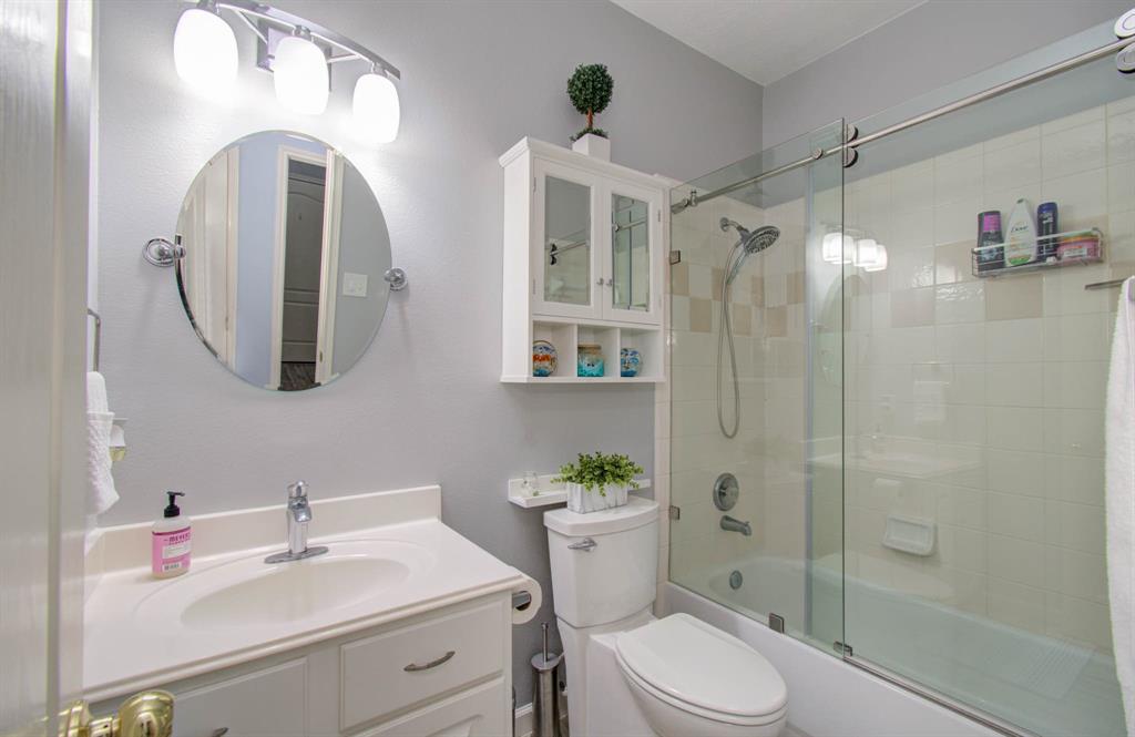 Bathroom offering a sliding shower glass and meticulously maintained cabinets