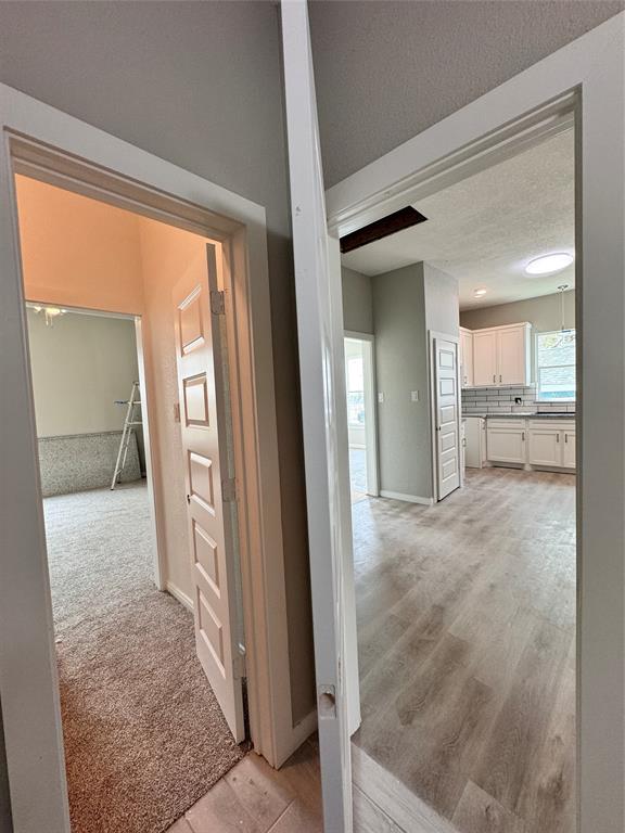 From the bathroom looking into the kitchen and to the closet and on to the primary bedroom