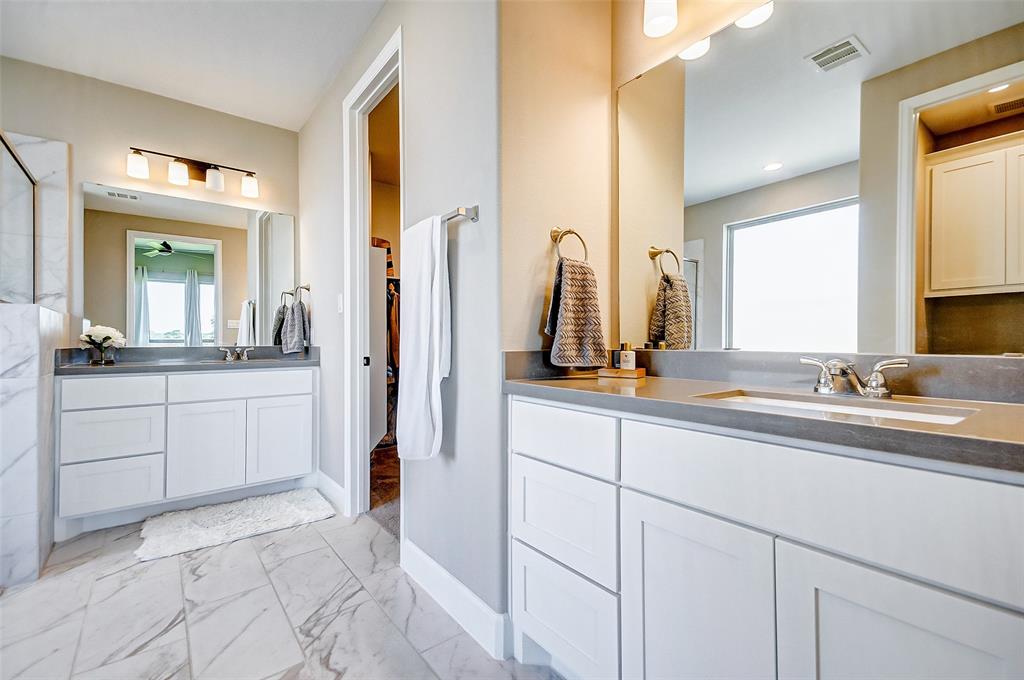 The primary bedroom also features a wall of windows, recessed lighting, and decorative ceiling fan.