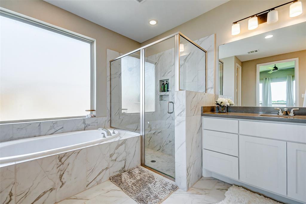 The primary bathroom has separate vanities with beautiful quartz countertops.