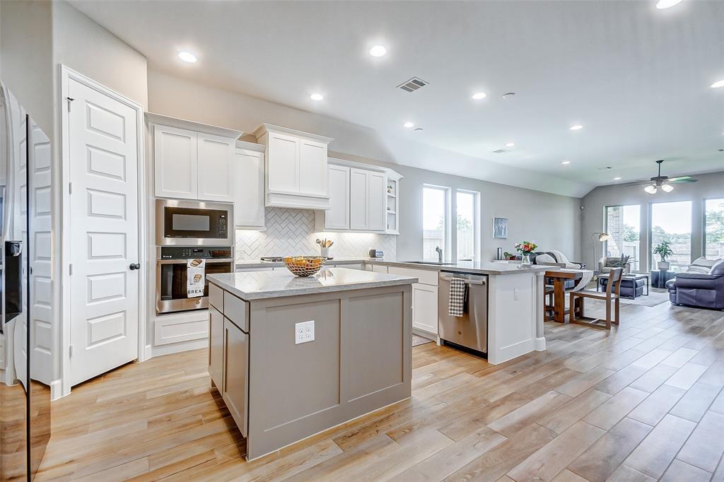 The open concept floor plan combining the kitchen, dining, and living areas is so spacious and check out the floors!  The owners selected this upgraded wood look tile that runs throughout all of the main areas.