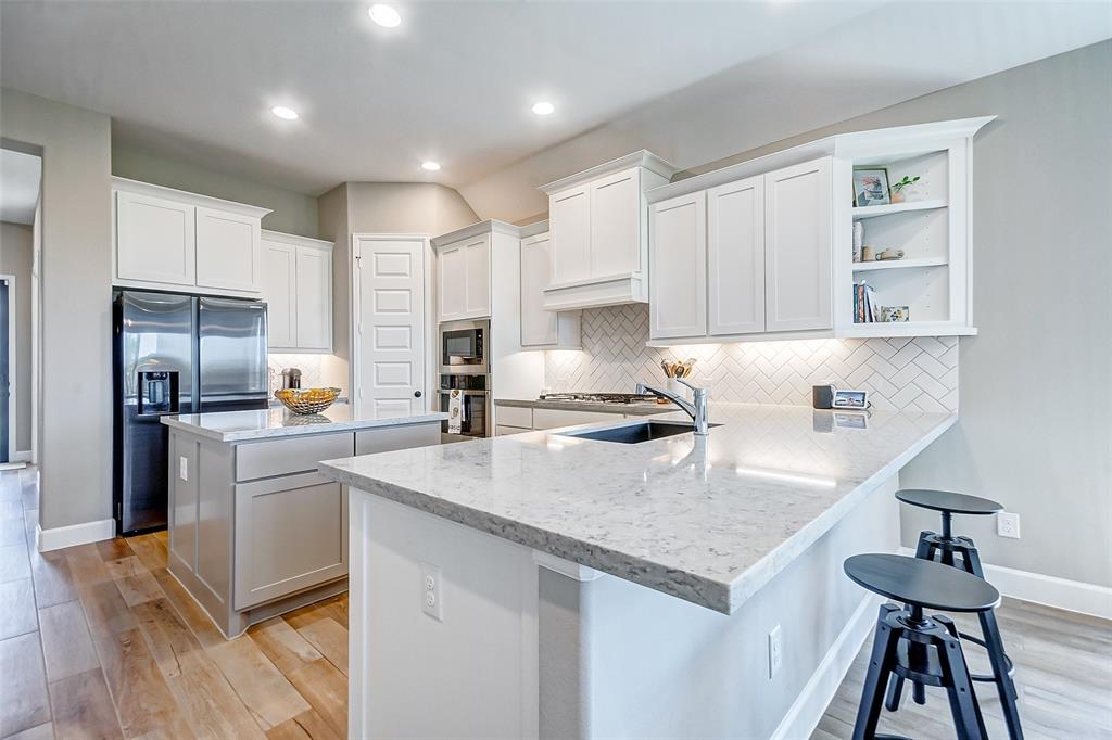 The kitchen features upgraded quartz countertops, under cabinet lighting, a 5 burner gas cooktop with griddle, and Blanco sink.  Tons of cabinet and counter space in this beautiful space.