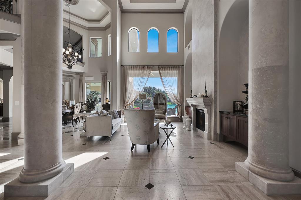 The formal Foyer is DIVINE leading to the lavish living offered in this amazing home with tons of upgrade features throughout such as columns, two-story ceilings, Travertine flooring and more!