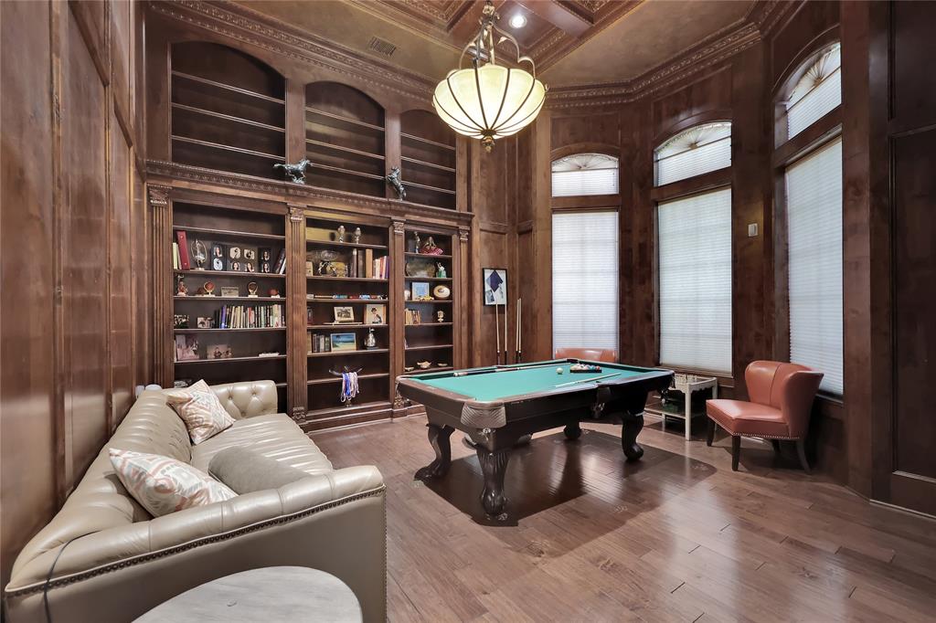 Luxurious Paneled Library with wonderful wood flooring to enjoy time reading in style between the arched windows, built-in shelving, sitting area, exercise room, and large bath with two walk-in closets!