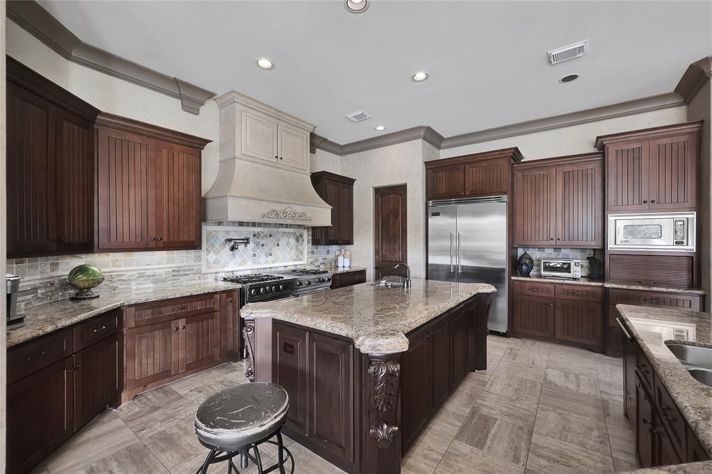 Alternate view of the Gourmet Kitchen with Breakfast Bar for more seating, custom tile surround and even sitting space as well as an open concept to allow for ease of conversation from one area to the next.