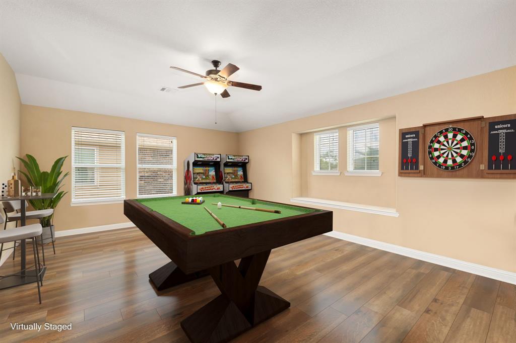 Come upstairs and enjoy a day of leisure in this fabulous game room! This is the perfect hangout spot or adult game room, this space features wood floors, high vaulted ceiling and custom paint.