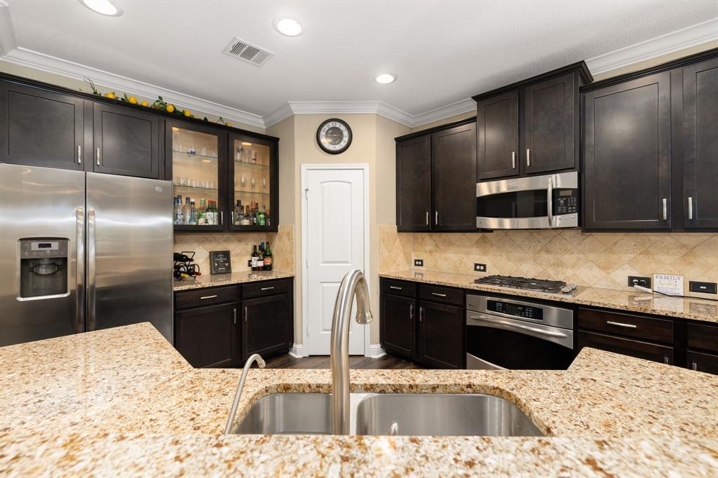 This kitchen is by far any chef’s dream! This spacious kitchen features crown molding, dark stained cabinets, granite countertops, SS appliances, tile backsplash, recessed lighting, extended counter space, granite kitchen island with a sink and space for breakfast bar and a pantry all overlooking your huge family room.