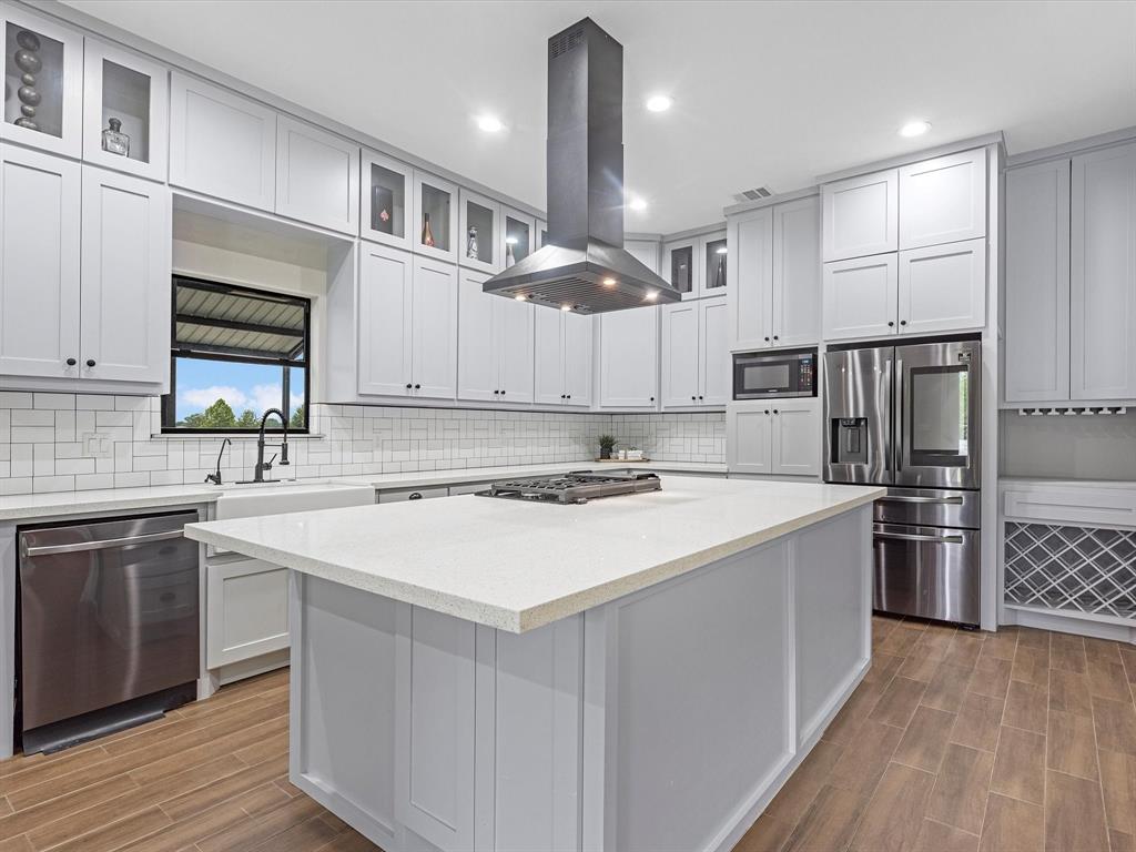 Kitchen features: Quartz counter tops, subway backsplash, black hardware, farm house sink, tons of cabinetry, dry bar with a wine rack, gas cook top, and this large island!