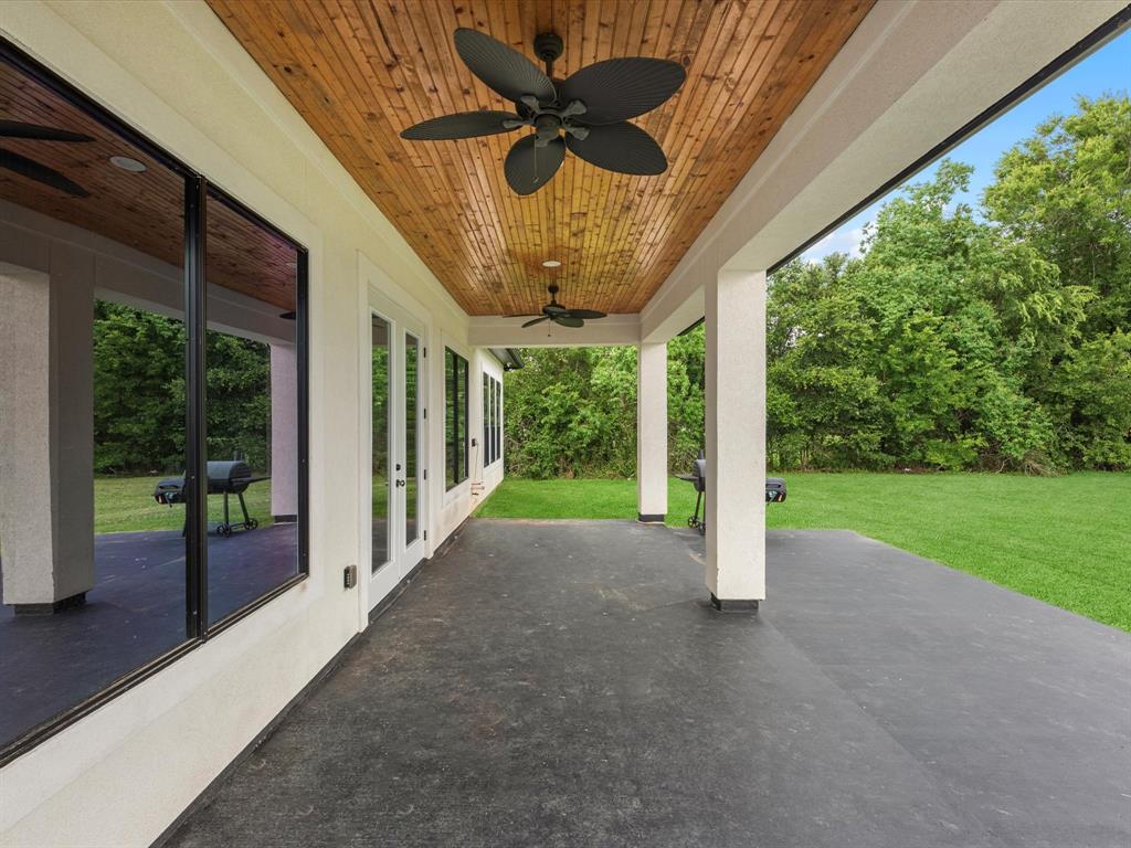 Back patio featuring cedar ceiling, ceiling fan, and a extended slab for entertaining.