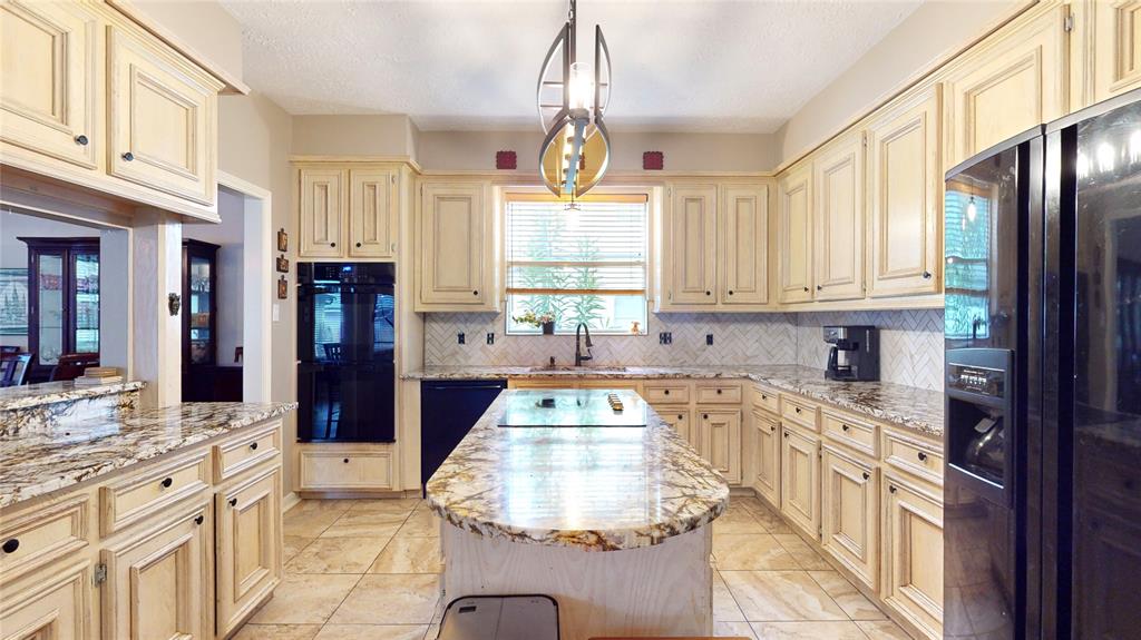 Upgraded granite & backsplash with island cooktop and refreshed lighting.