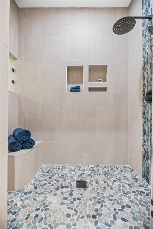 Separate large shower with seat accommodations. & tile accents